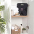 Black digital bathroom scale on shelf with towels and soap, styled in modern bathroom