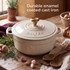 Cream cast iron casserole dish with gold knob on rustic kitchen table.