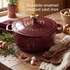Red cast iron casserole dish on hob with vegetable stew being stirred