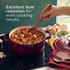 Red cast iron casserole dish with steaming chilli stew on hob, lid and ingredients beside