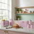 Kitchen scene with pastel pink toaster, kettle, bread bin and canisters on worktop