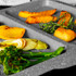 Grey speckled roasting tray with assorted roasted vegetables and herbs