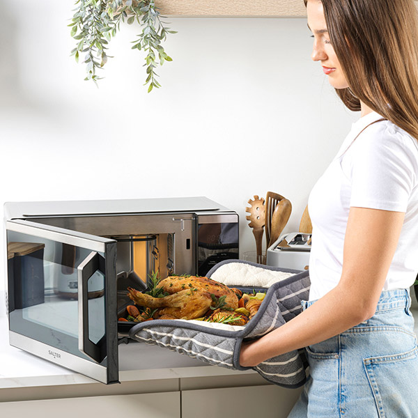 A roast chicken being put into a Salter DuoWave Air fryer Microwave