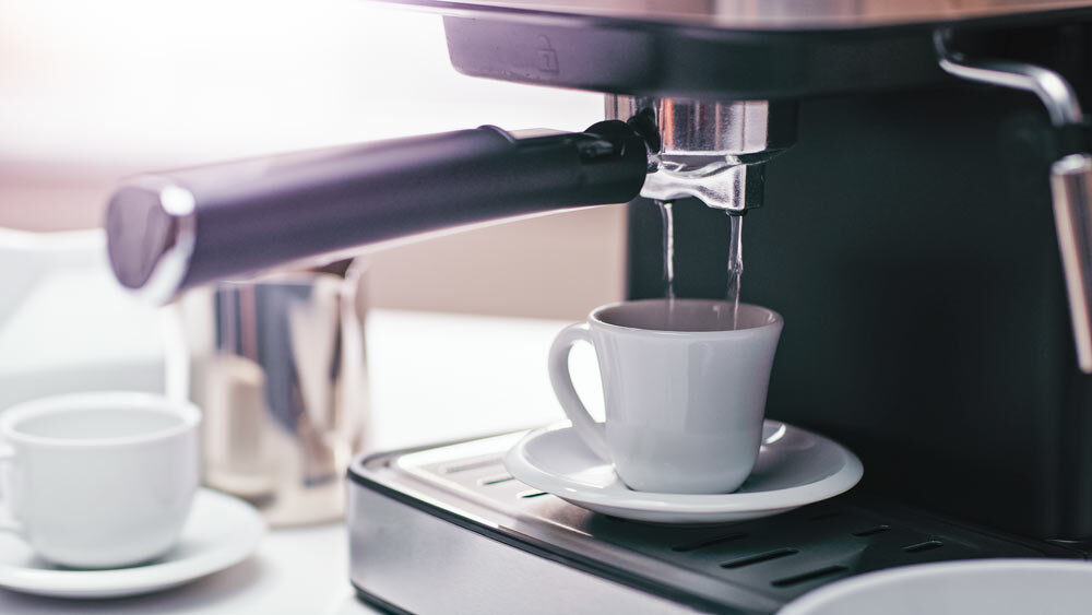 Running clean water through the espresso machine into a cup