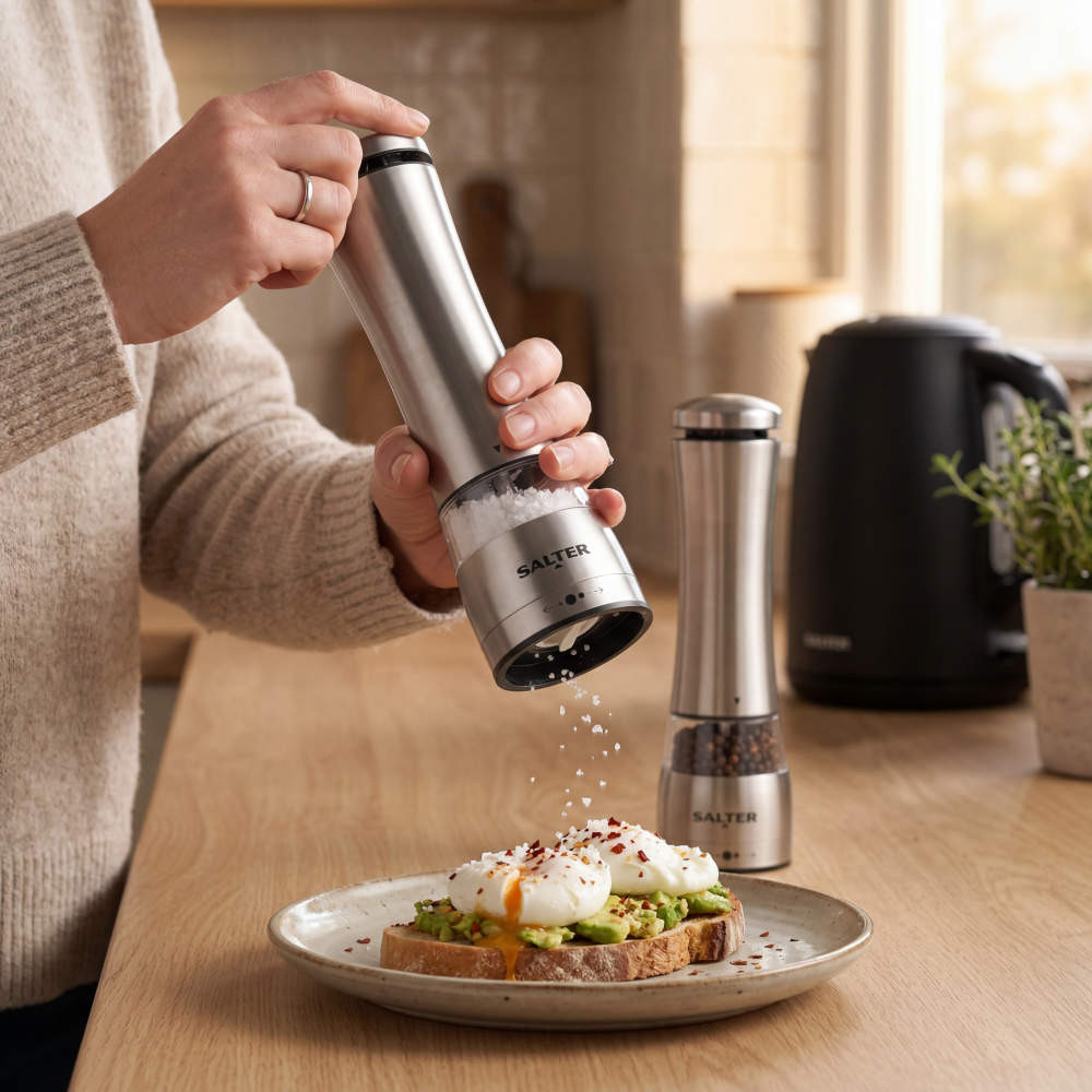 Salter electric salt grinder in use next to pepper grinder on kitchen counter