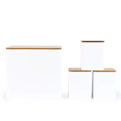 Set of four white kitchen storage canisters with bamboo lids, shown in different sizes.