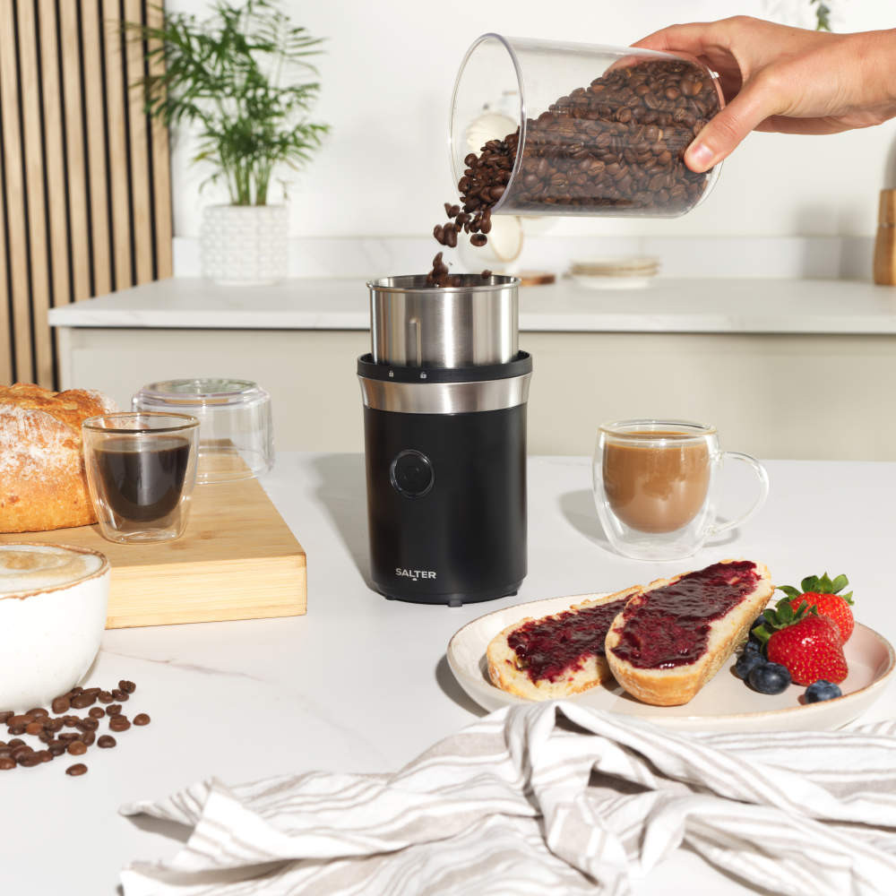 Salter coffee machines and grinder on kitchen counter with mugs and pastries