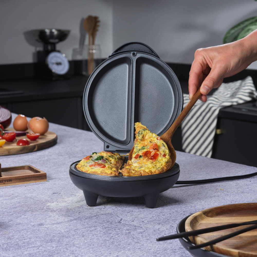 Black electric omelette maker with open lid, showing non-stick cooking plates
