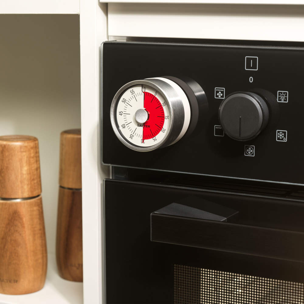 Analogue kitchen timer attached to a black oven