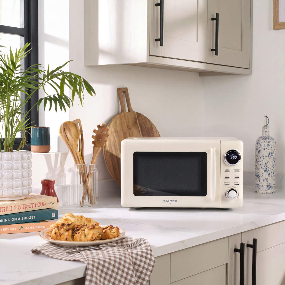 Cream microwave oven on kitchen counter with digital display