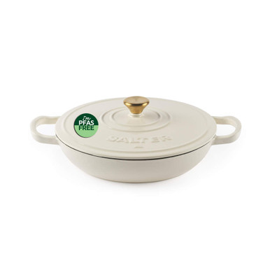 Cream cast iron casserole dish with lid, gold knob, PFAS free label visible