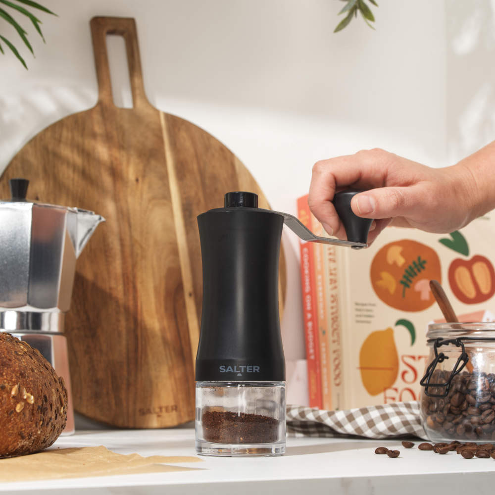 Black manual coffee grinder with removable handle, Salter branding, product image.