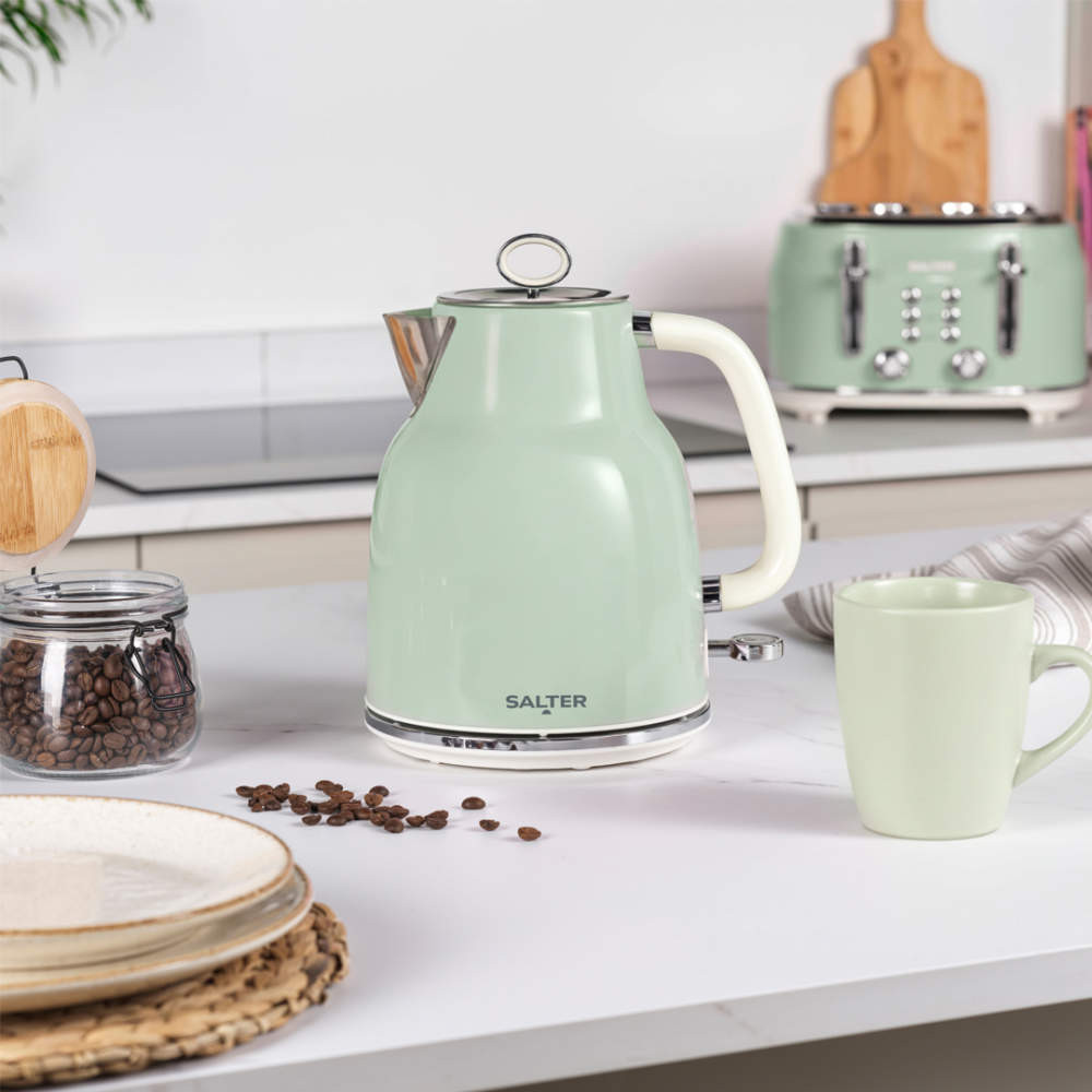 Green electric kettle on kitchen counter, next to matching mug and coffee beans.