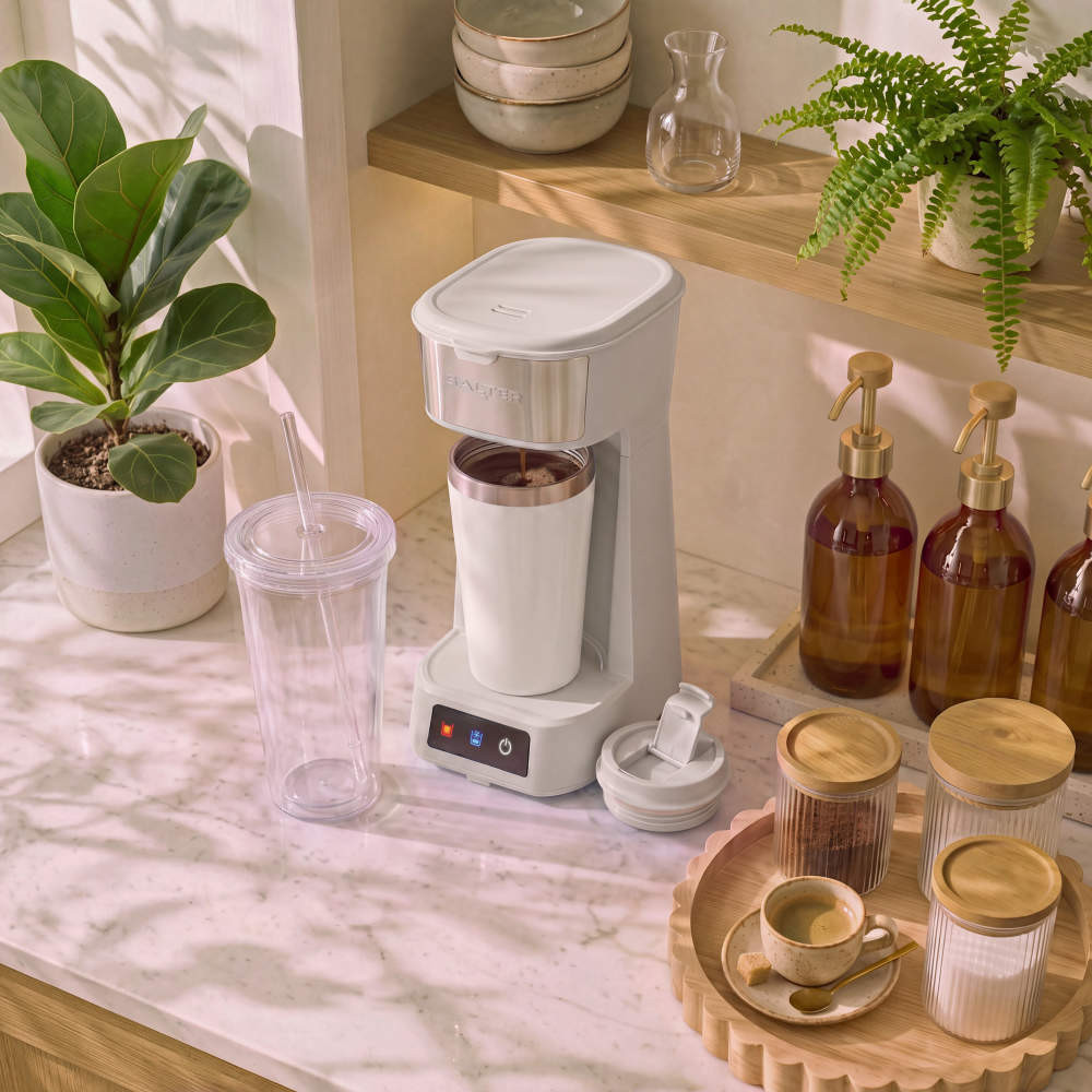 Grey single-serve coffee maker with reusable cup and straw tumbler