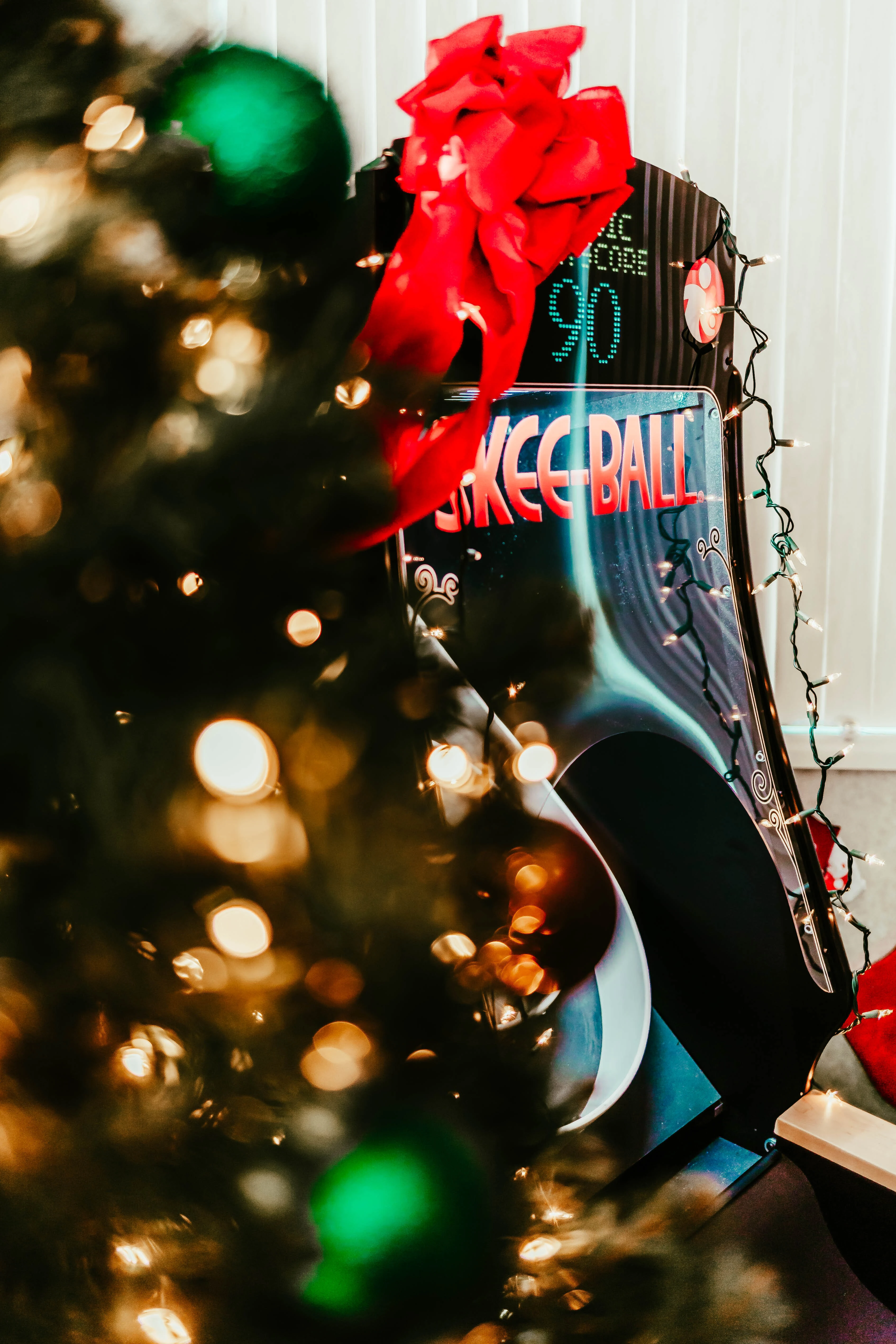 Skee-Ball alley with a red bow beside a Christmas tree