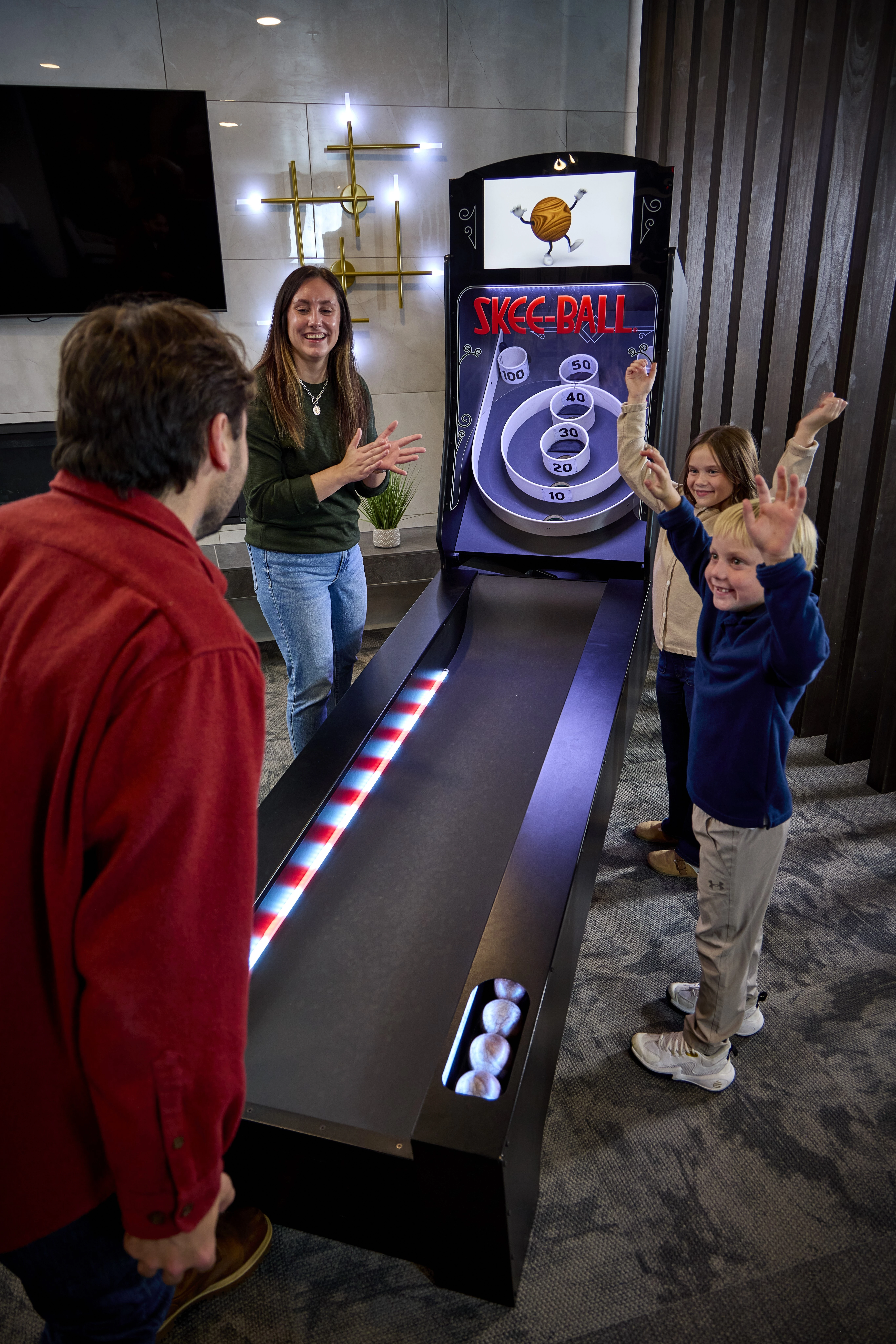 Family playing Skee-Ball together on game night