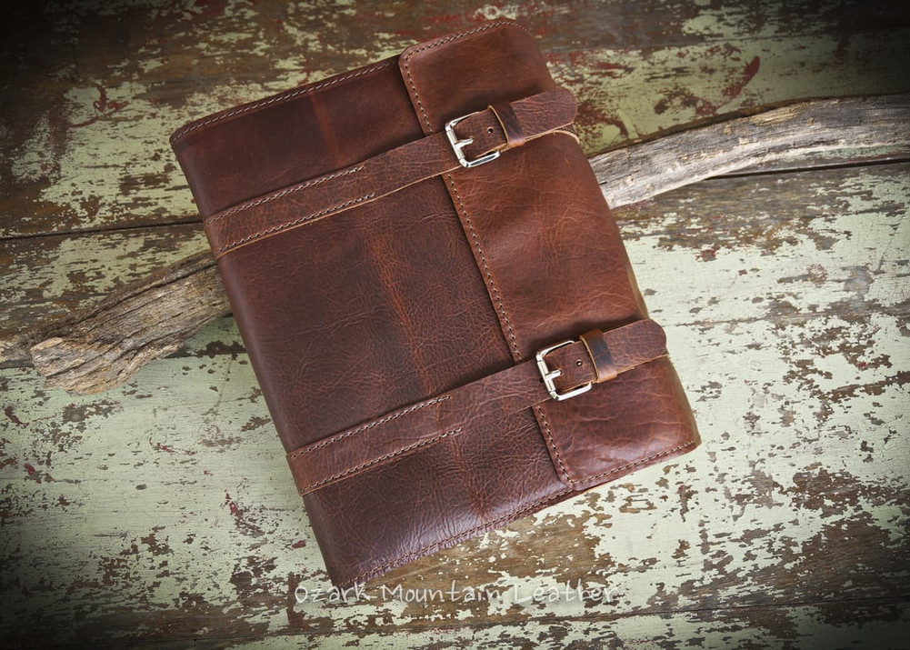 Handmade brown bison leather Bible cover with double straps and buckle closure, featuring natural grain texture and rustic full-grain finish.