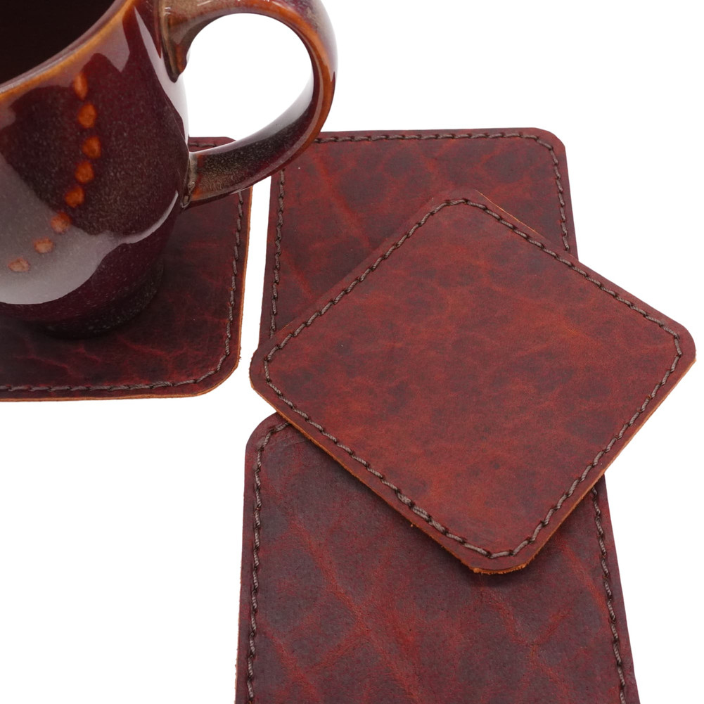 Handmade brown bison leather drink coasters showing the natural grain and unique texture of genuine American bison leather.