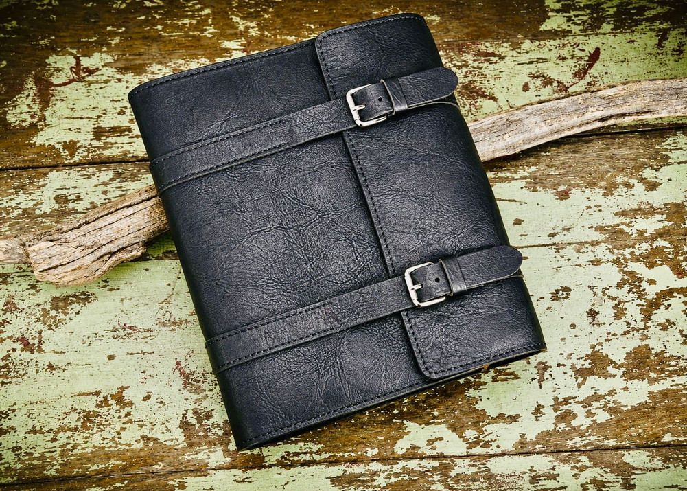 Handmade Black bison leather Bible cover with double straps and buckle closure, featuring natural grain texture and rustic full-grain finish.