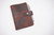 close-up of black bison leather showing natural grain and soft texture on a handmade Bible cover. Features snap closure and pen loop for added function and durability.