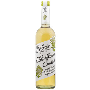 A 500ml glass bottle of Belvoir Elderflower Cordial with a white floral label, showing the light golden cordial inside.