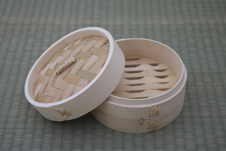 One Tier Bamboo Steamer with Lid 6 inch, showing open steamer basket and woven bamboo lid on a green textured surface.