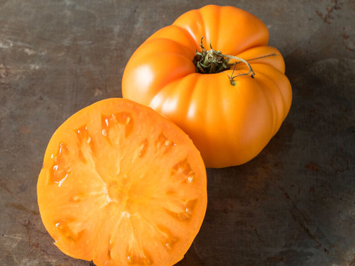 Large yellow beefsteak tomatoes with slightly ribbed shape, Yellow Brandywine variety