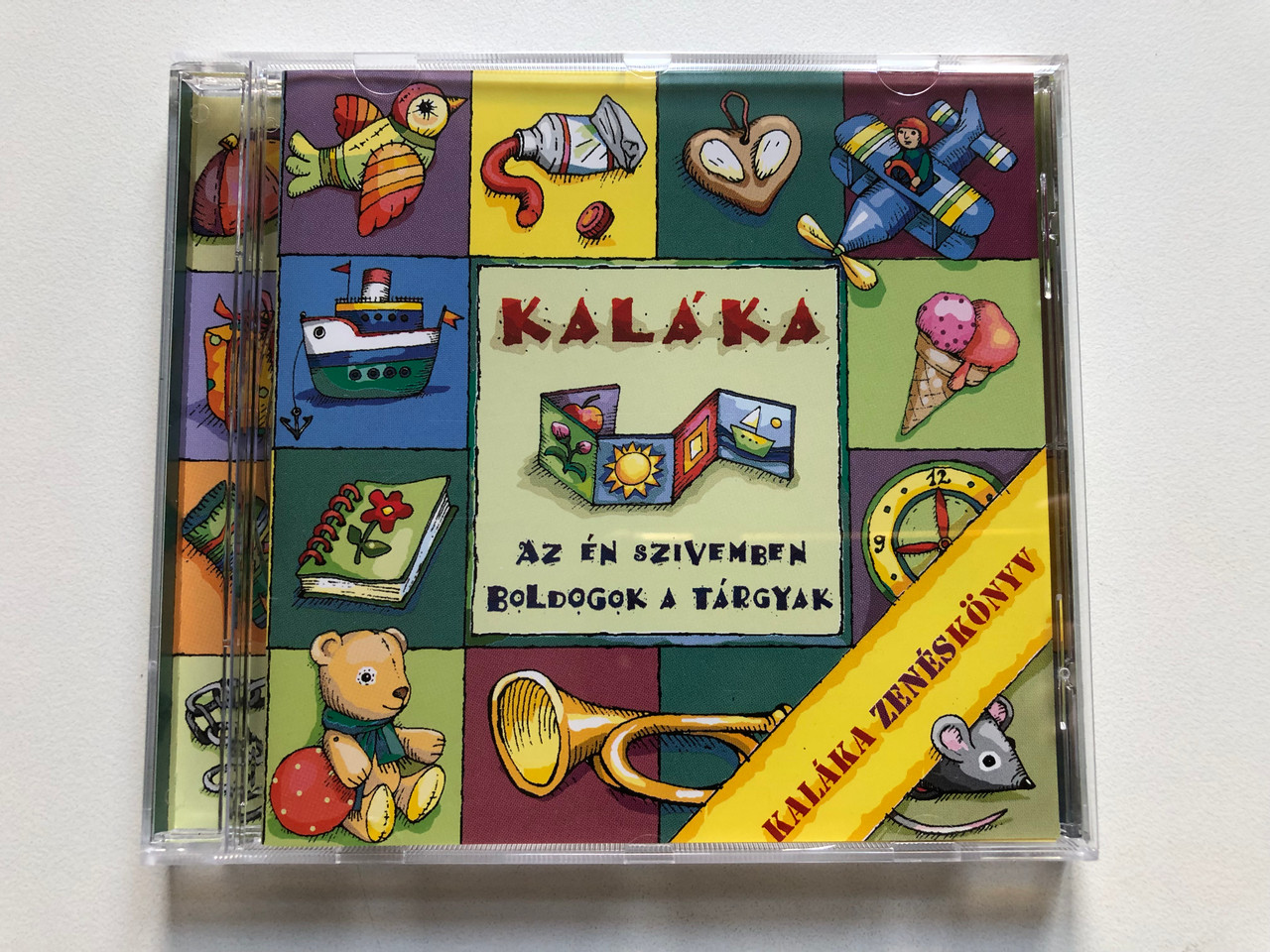 https://cdn11.bigcommerce.com/s-62bdpkt7pb/products/0/images/328657/Kalka_Az_n_Szvemben_Boldogok_A_Trgyak_Kalka_Zeneskonyv_Gryllus_Audio_CD_2001_GCD_022_1__27353.1711018109.1280.1280.JPG?c=2