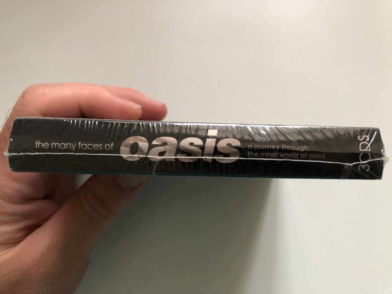 https://cdn11.bigcommerce.com/s-62bdpkt7pb/products/0/images/345386/The_Many_Faces_Of_Oasis_A_Journey_Through_The_Inner_World_Of_Oasis_Music_Brokers_3x_Audio_CD_2017_MBB7245_3__93396.1724098159.1280.1280.JPG?c=2