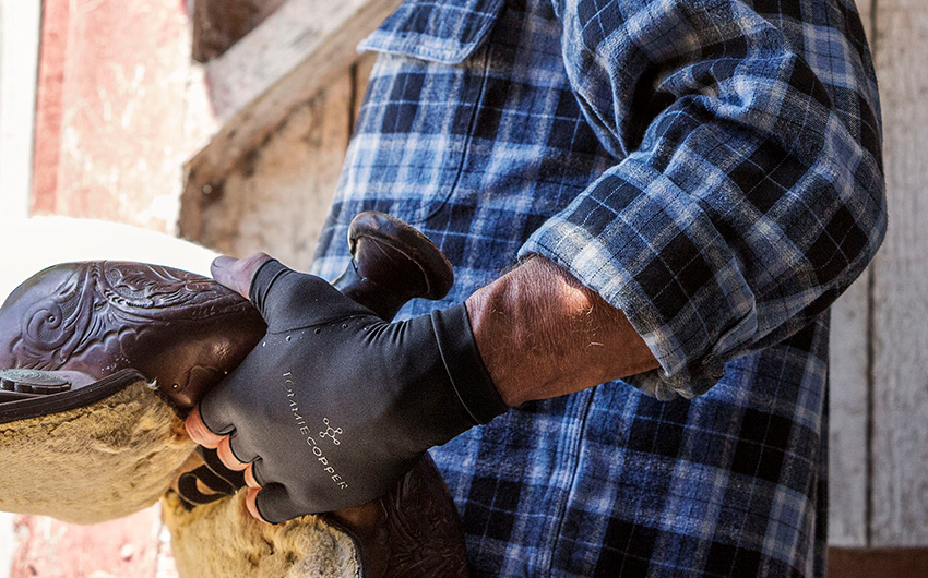 A man wearing black Tommie Copper Half-Finger Compression Gloves.