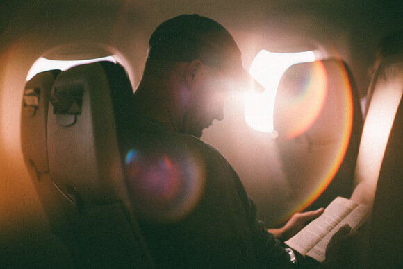  Man reading a book on a plane