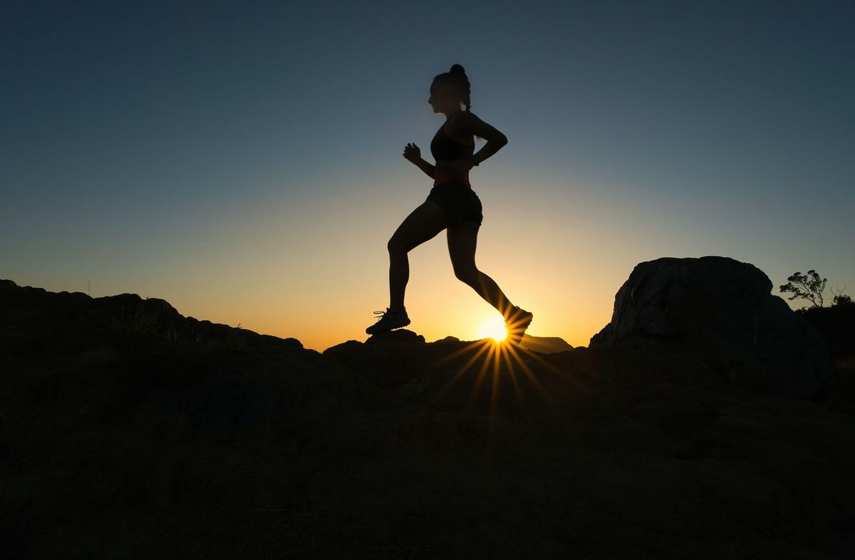 A woman hiking and showing what compression pants can do