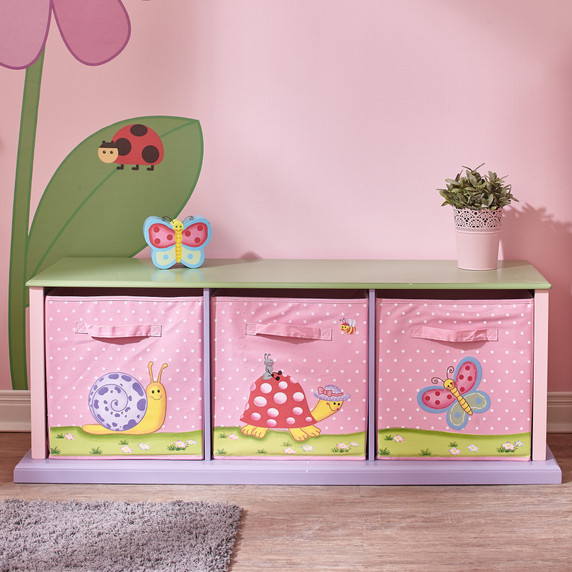A product image featuring Fantasy Fields' Magic Garden Organizational Bins. The image showcases three colorful bins popping out from a solid wood casing. Cheerful butterfly and insect decorations adorn the bins and the wood casing, adding a playful touch. The bins are designed for convenient storage of games and books, providing a stylish and organized solution. The hand-carved and hand-painted frog-princess and friendly butterfly designs bring a whimsical charm to the bins. Suitable for ages 3 and up, these durable and non-toxic bins spark children's imagination and sense of wonder.