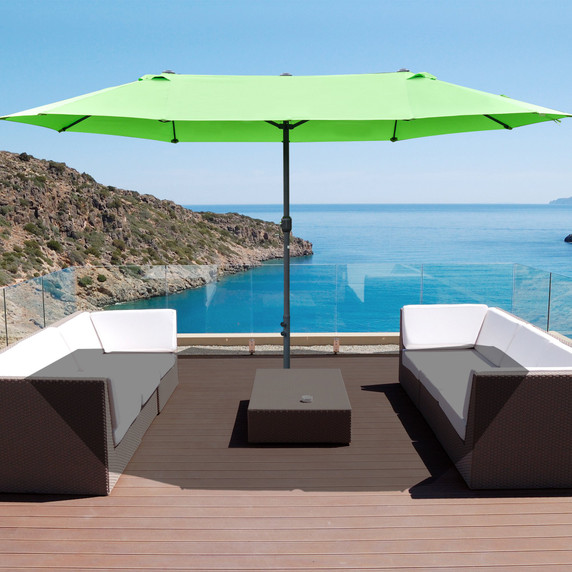 A fresh and vibrant green outdoor umbrella featuring a double-sided crank sun shade and cross base, providing ample shade and sun protection in natural outdoor environments