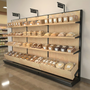 12ft single-sided wood bakery gondola rack positioned against a wall, fully merchandised with packaged bread loaves, bottom bins, and aisle marker signs.