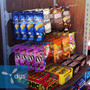 Rackform Black Peghooks for Hangbar 8D shown attached to a hangbar and holding candy on a display.