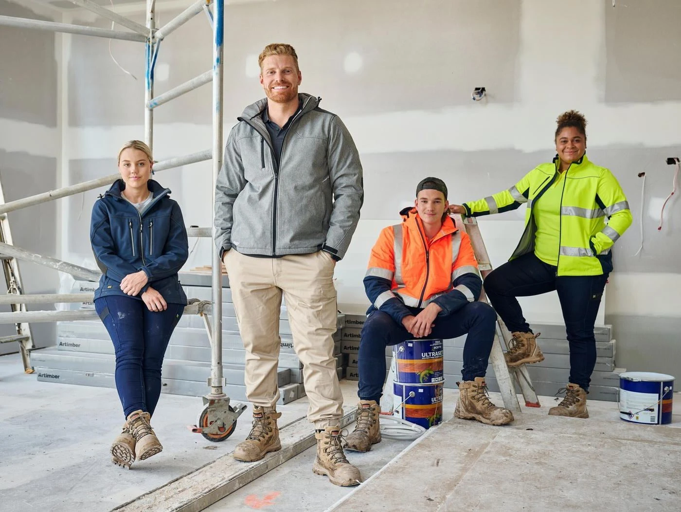 Four workers on a building site in workwear and hi-vis