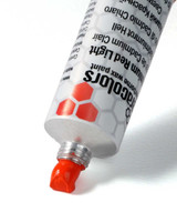 Ceracolors Cadmium Red Light tube squeezing out beeswax-based paint onto white background showing thick paste consistency and high-chroma coverage