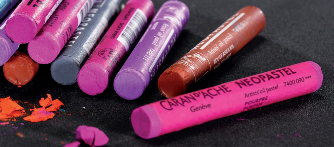 Caran d’Ache Neopastel pink oil pastel sticks with purple and red shades on black paper demonstrating the soft texture of the oil pastel