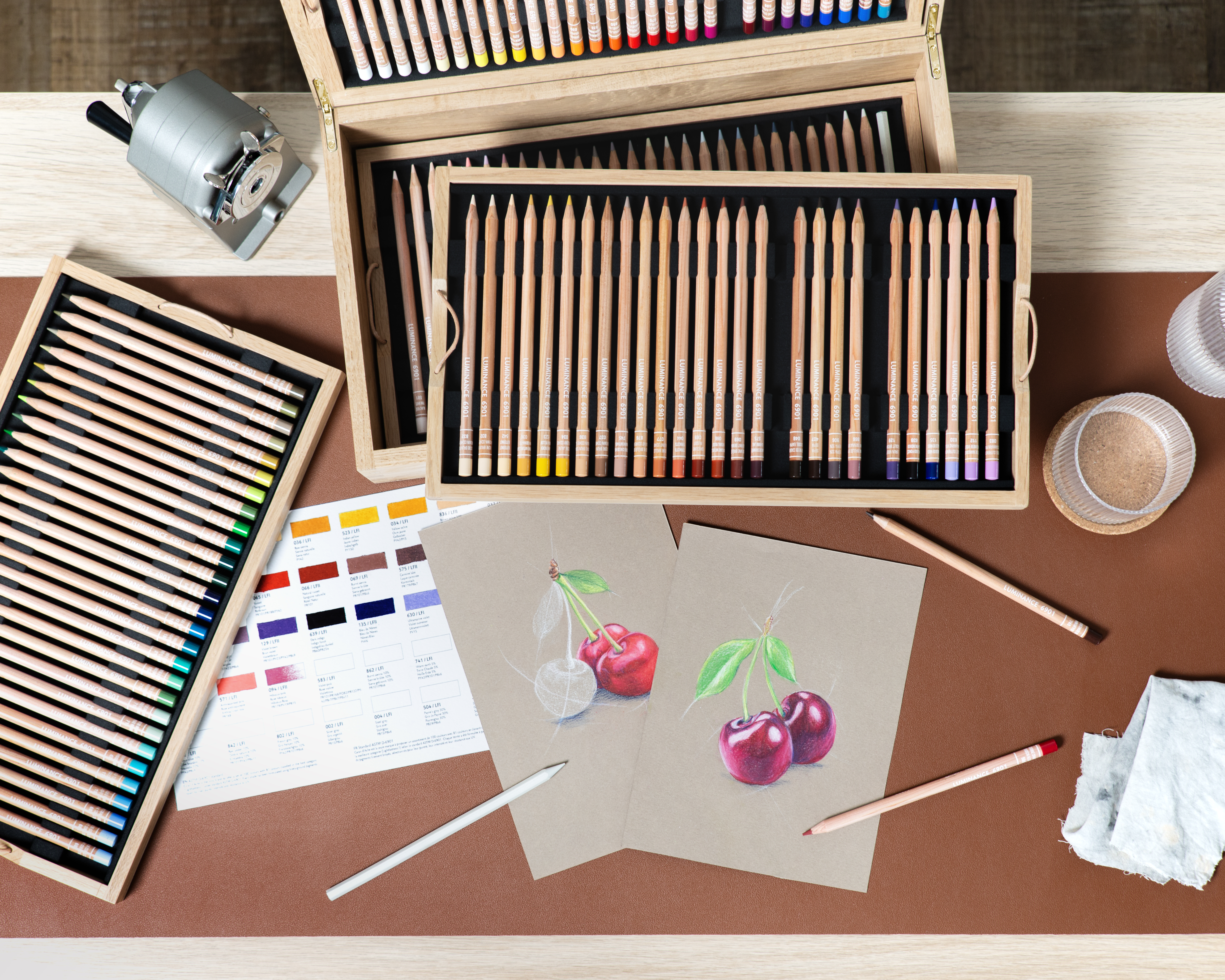 Open Luminance 6901 wooden cases with full trays and cherry drawings—professional lightfast colour pencils for fine art.