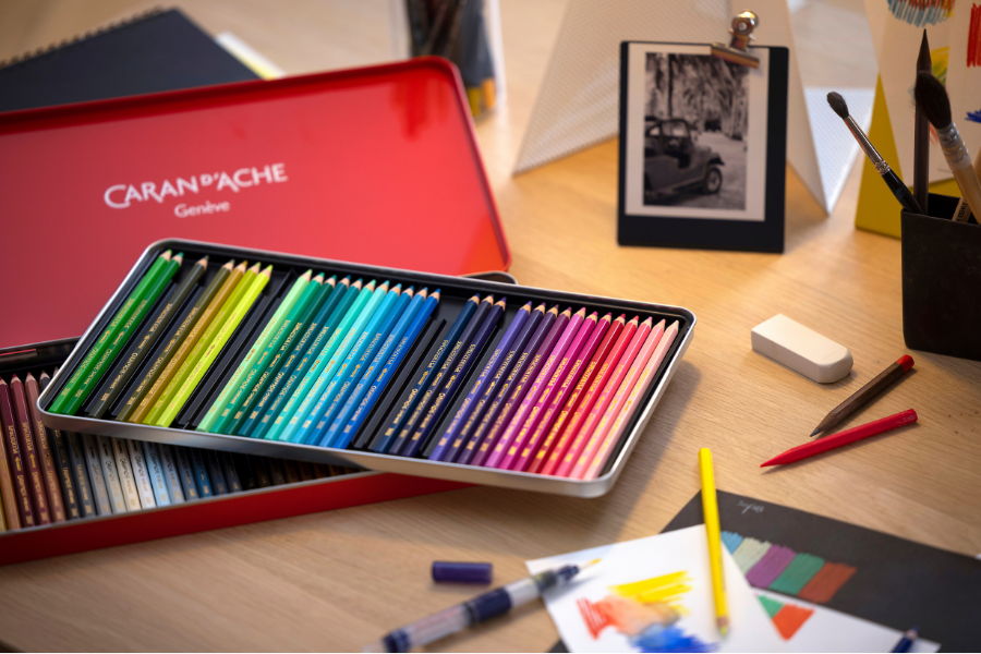 Caran d’Ache coloured pencils set in red metal tin on studio desk — largest range at Kadmium Art & Design Supplies, Sydney Art Shop