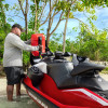 Man refuelling a red Sea-Doo from the LinQ 20 L fuel caddy at the beach