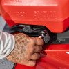 Close-up of a hand locking the LinQ fuel caddy latch onto the base