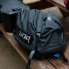 LinQ 40 L roll-top bag sitting on a picnic table beside a cooler