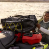 Rider strapping the LinQ Explorer Bag above red LinQ fuel caddies on a Sea-Doo