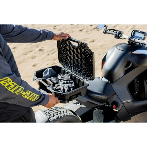 Rider loading gear into a LinQ 10 L modular box on a Can-Am vehicle at the beach