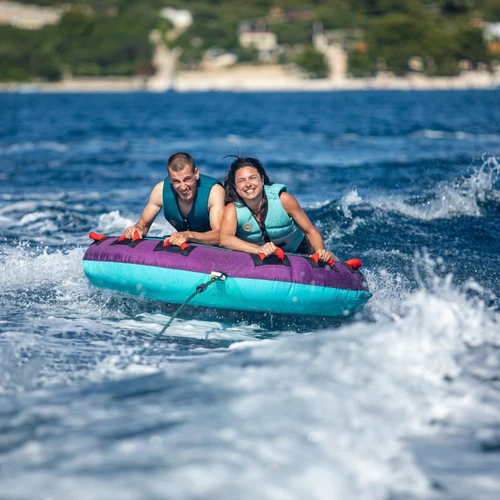 Two riders on the Jobe Droplet towable being pulled across the water