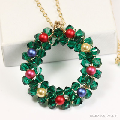 Christmas wreath pendant on gold chain necklace with emerald green crystals and multicolored pearl ornaments handmade by Jessica Luu Jewelry