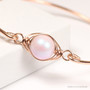 10mm iridescent light pink pearl bangle bracelet in 14K rose gold filled wire wrapped setting handmade by Jessica Luu Jewelry