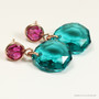 Faceted blue green Austrian crystal pendants dangle from fuchsia purple Austrian crystal posts in 14K rose gold filled metal handmade by Jessica Luu Jewelry